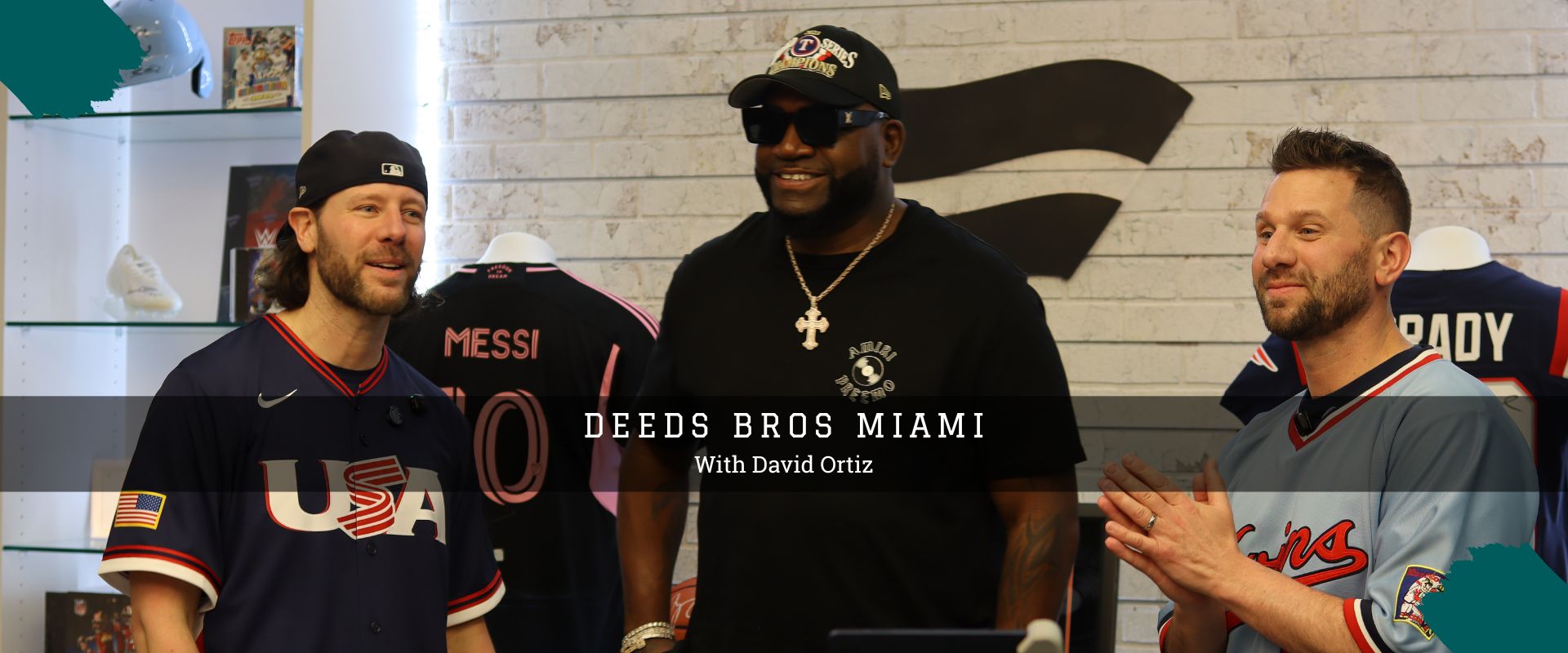 David Ortiz Jeremy and Josh Deeds standing in a room with sports jerseys displayed on mannequins.